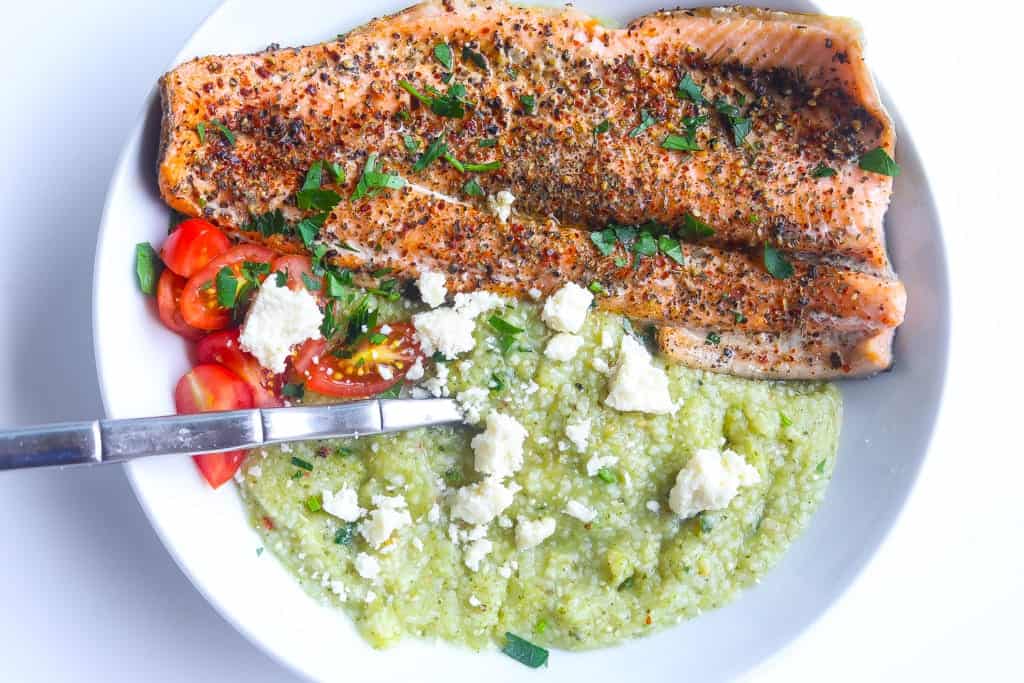 fish and grits in a bowl with tomatoes