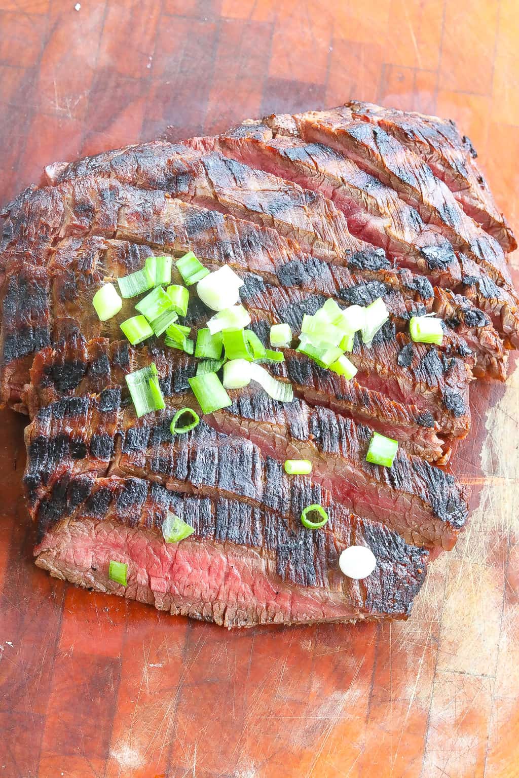 grilled flank steak sliced and topped with green onions