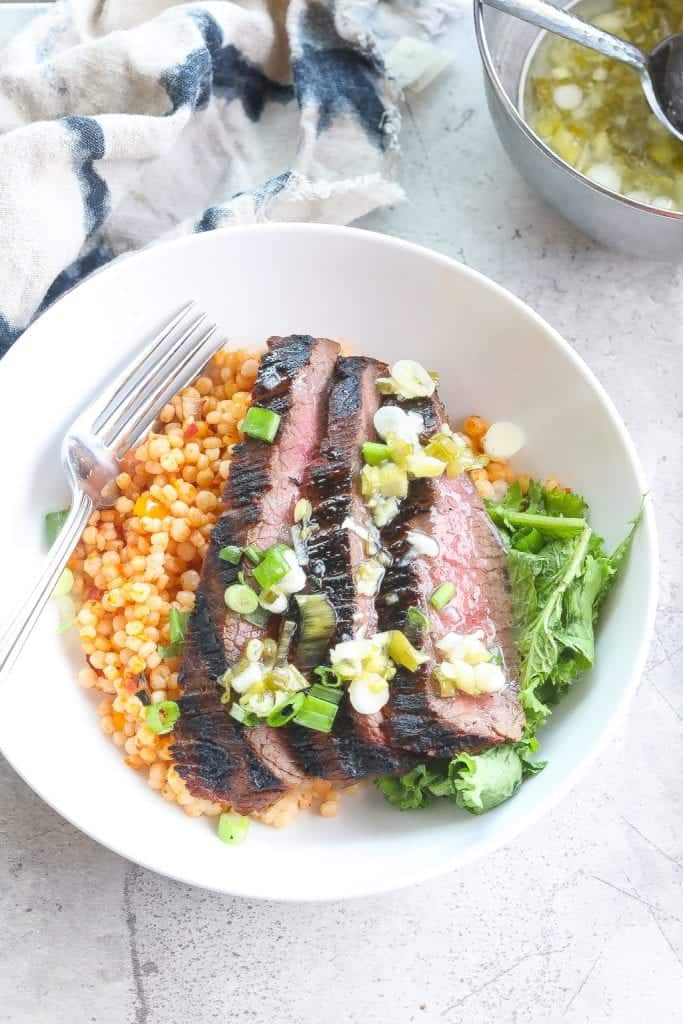 grilled flank steak bowl with couscous and greens