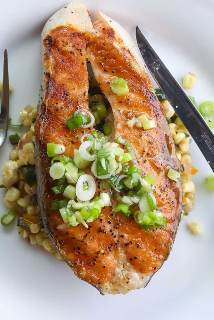 salmon steak topped with green onions vinaigrette