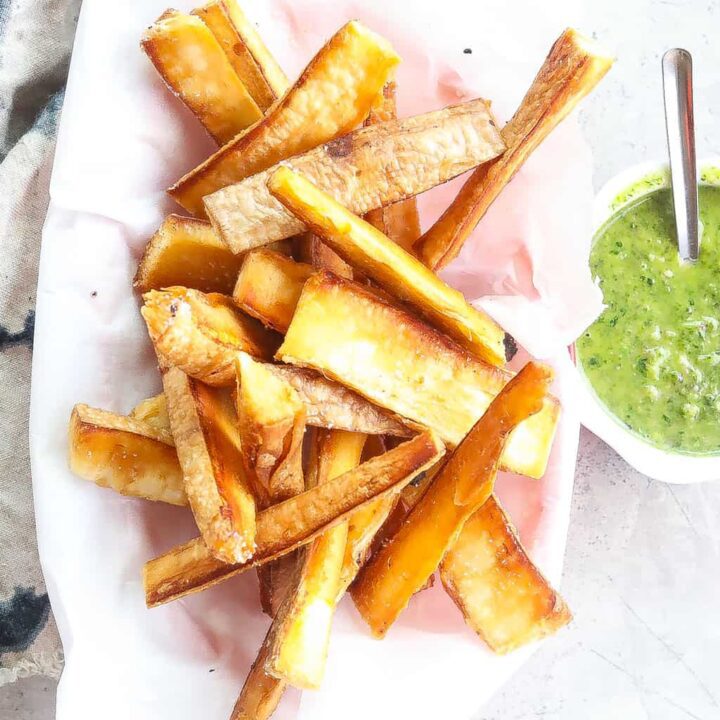 yuca fries with green dipping sauce on a platter