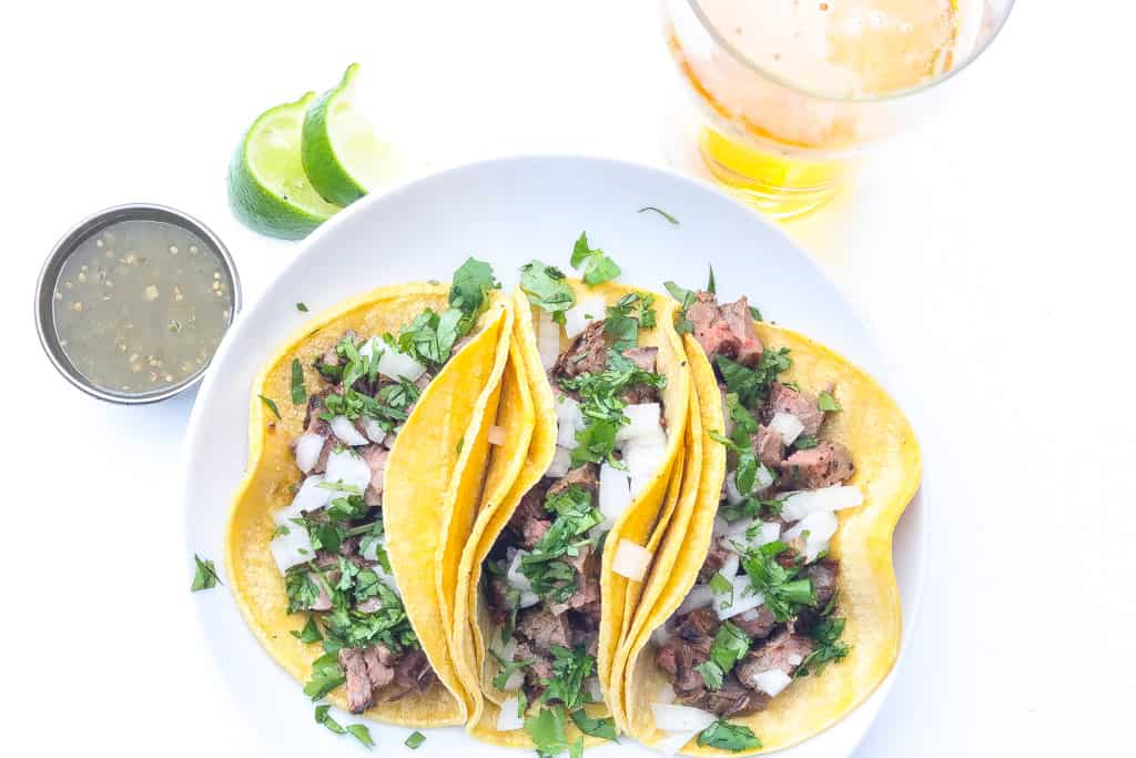 three street tacos on a white plate