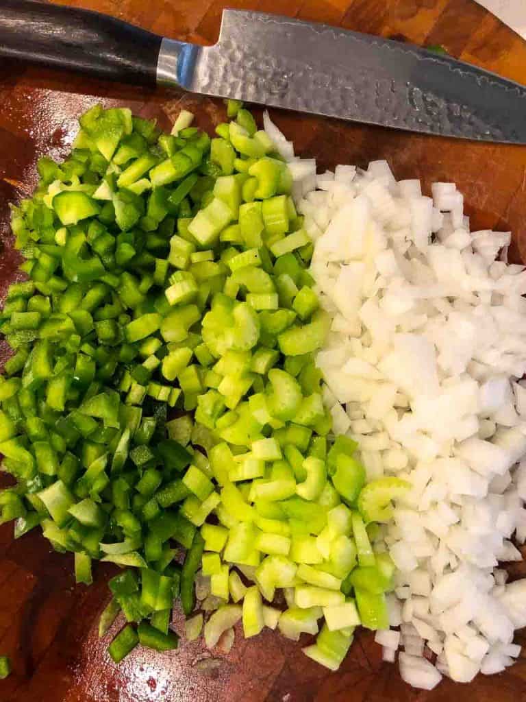 diced celery, onions, bell peppers on a cutting board