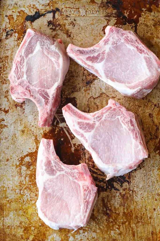 raw pork chops on a platter