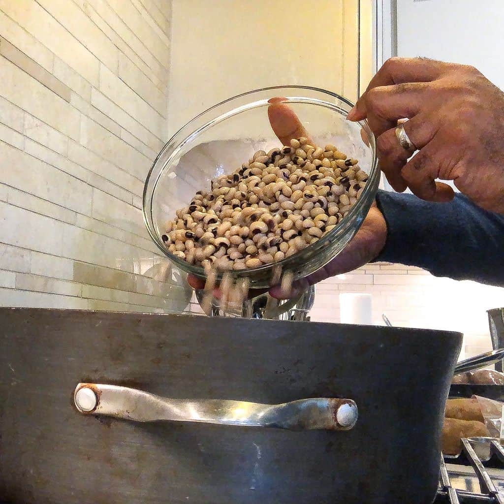 adding blackeyed peas to a pot