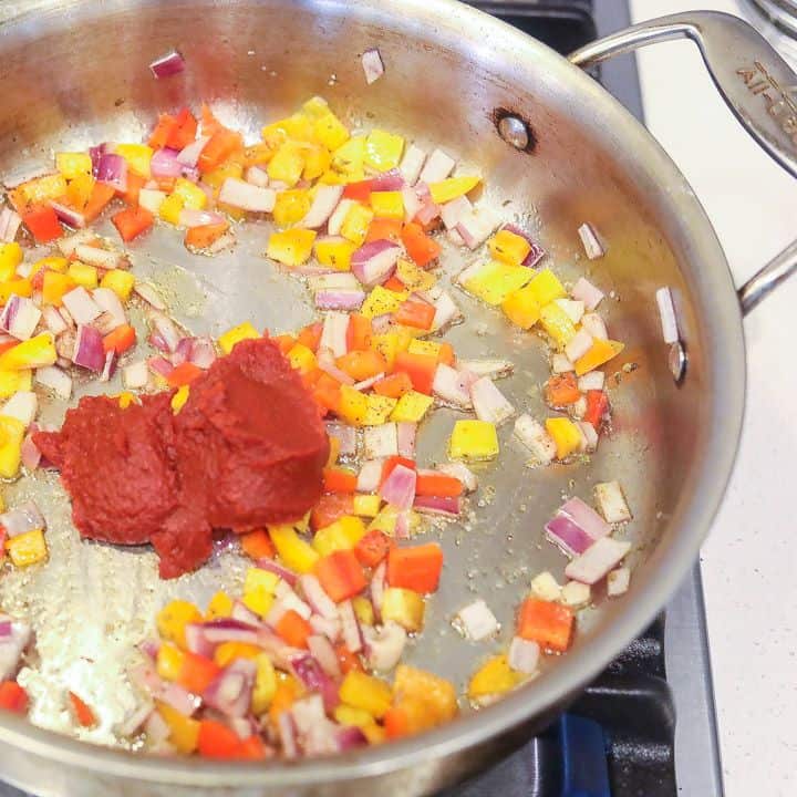 garlic, onions, peppers and tomato paste cooking in a skillet