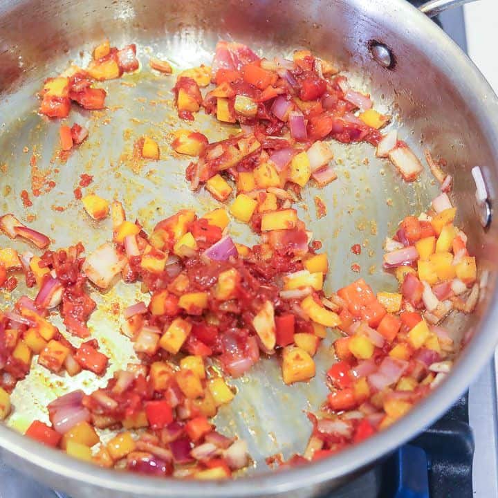garlic, onions, peppers and tomato paste cooking in a skillet