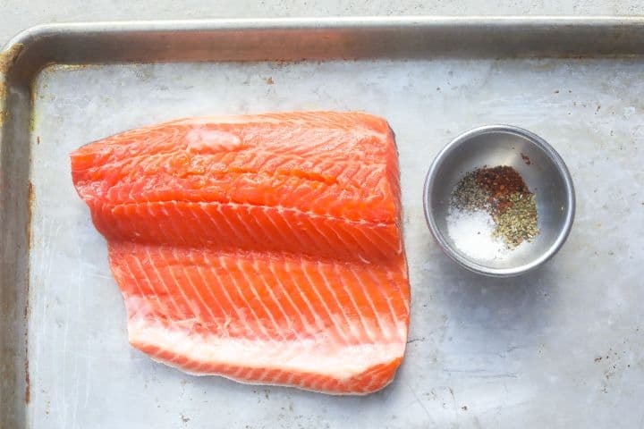 raw trout with spice seasonings on a tray