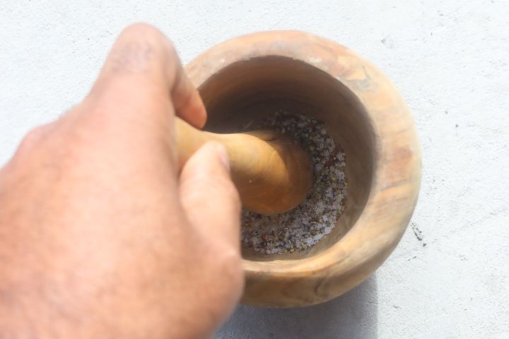 spices in a mortar being grinded with a pestle