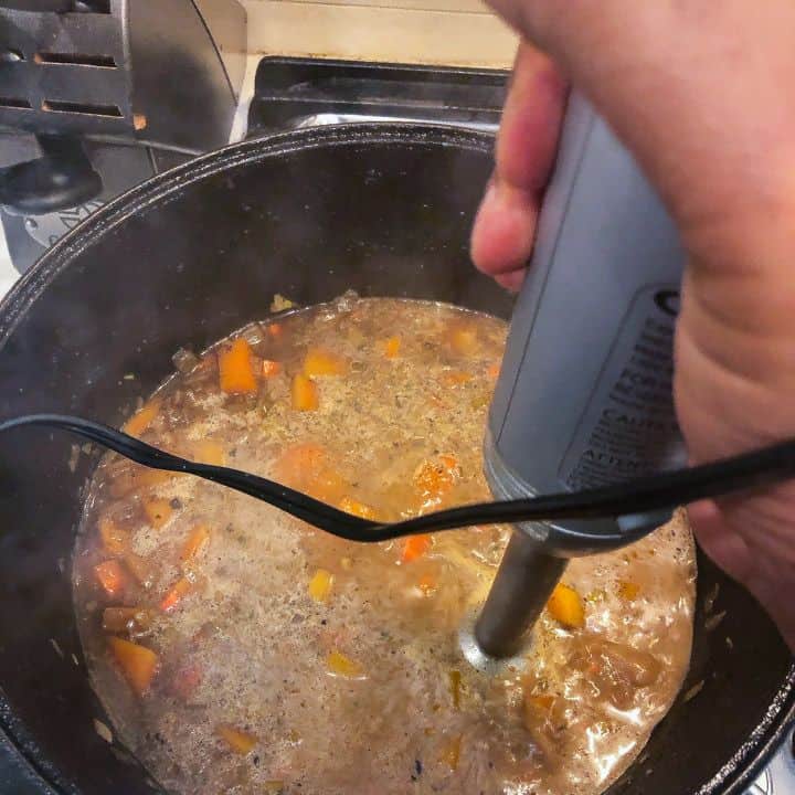 hand blender being used to puree soup ingredients