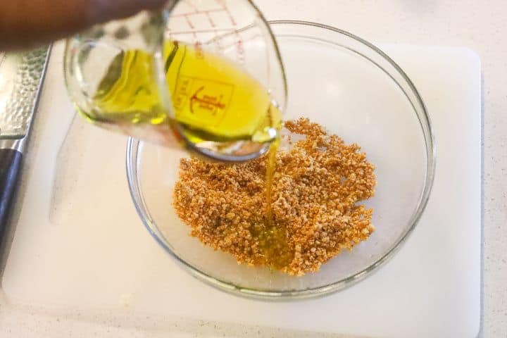 oil being added to bowl of spices
