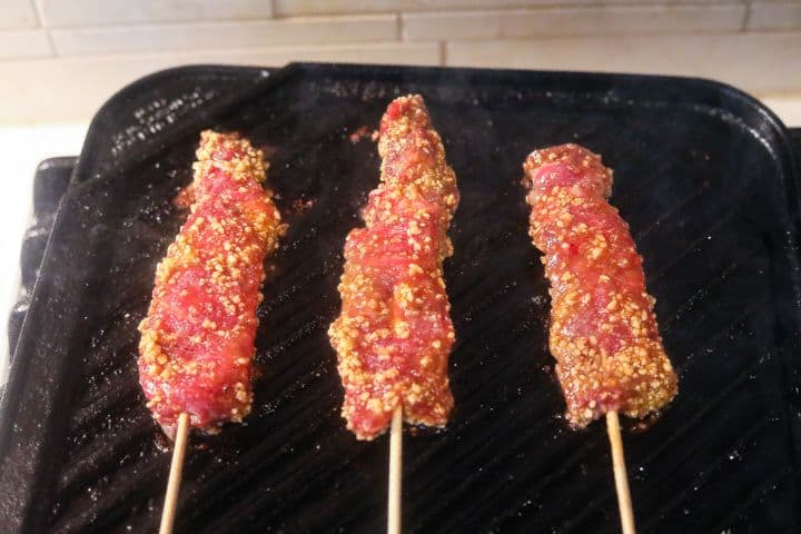 beef skewers cooking on the grill