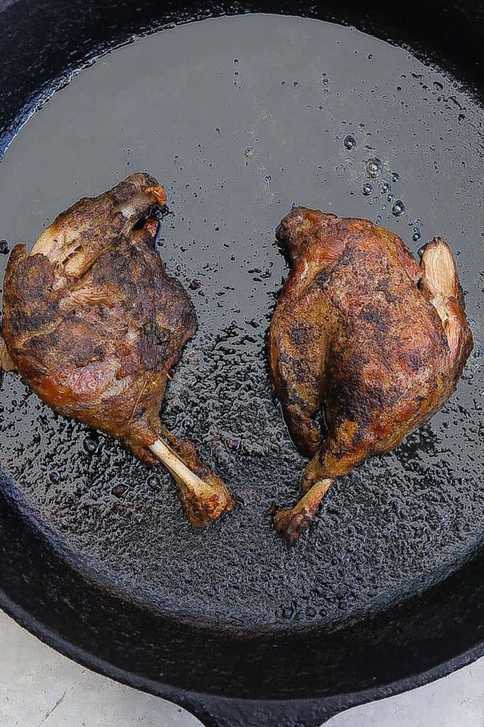 duck confit in skillet cooking
