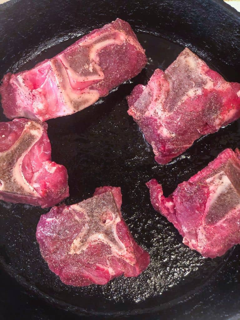 neck bones browning in skillet