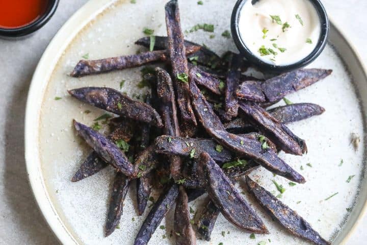 purple potato fries on a plate with mayonnaise