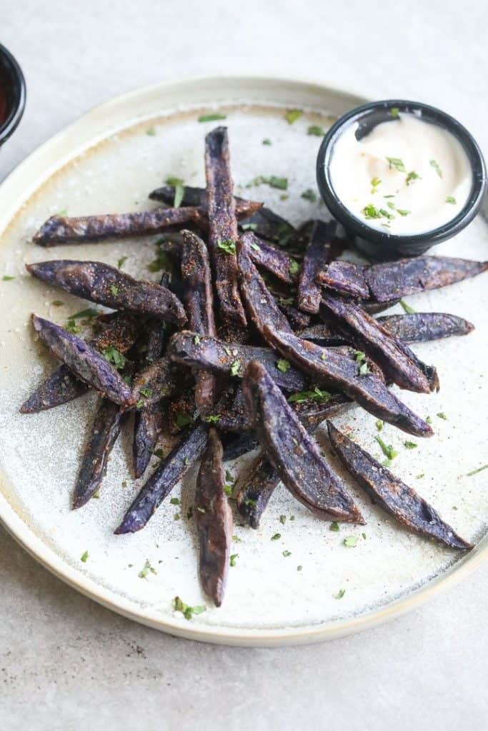 purple potato fries on a plate with mayonnaise