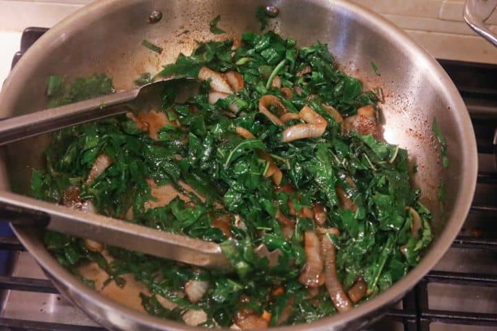 collard greens with onions sauteing in pan