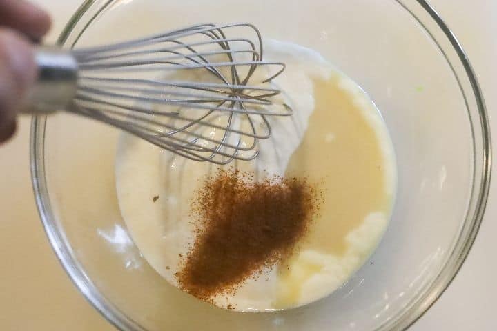 mixing crema ingredients with a whisk in a bowl