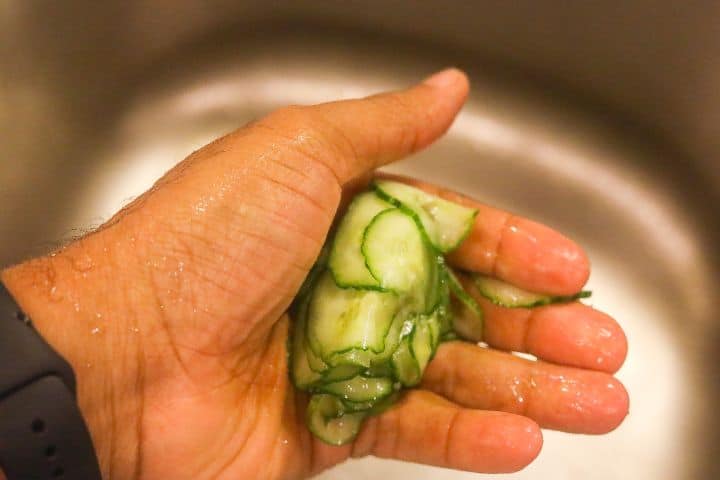 squeezing water from cucumber slices