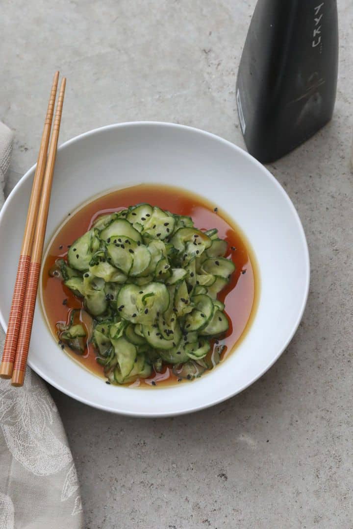 cucumbers topped with sauce in a white bowl