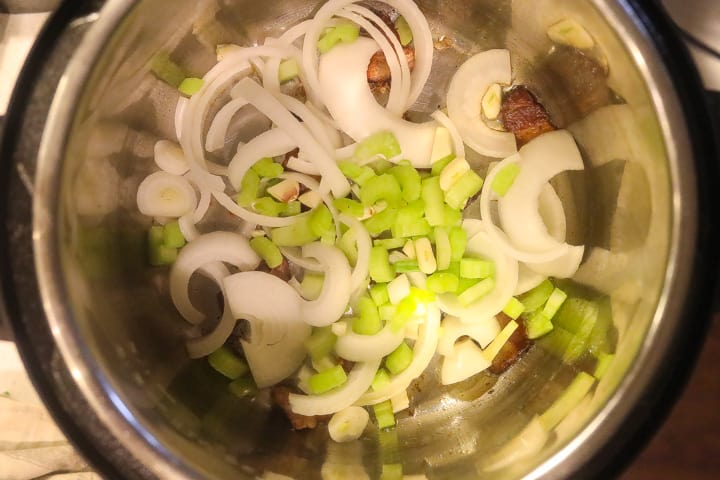 onions and celery sauteing in a pan