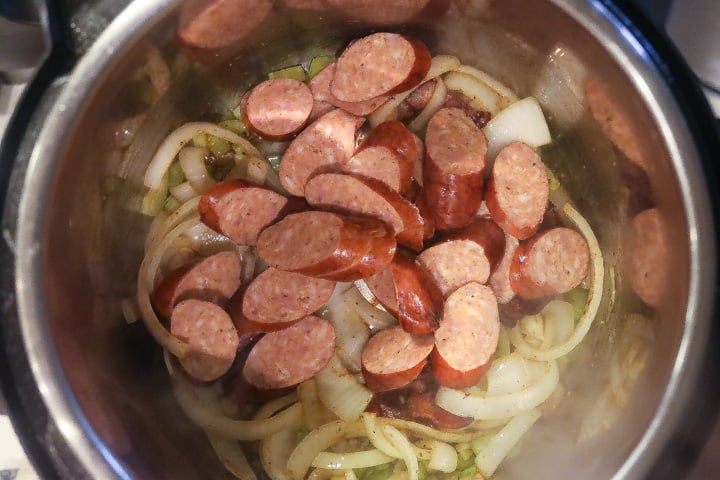 sausage and vegetables cooking in a pan