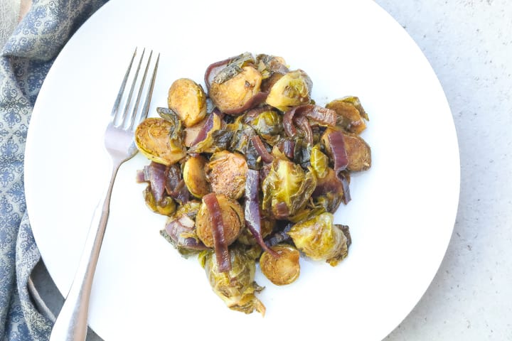 braised brussel sprouts with onions on white plate
