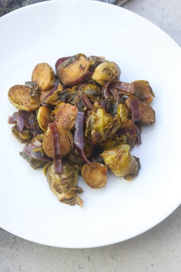 braised brussel sprouts with onions on white plate