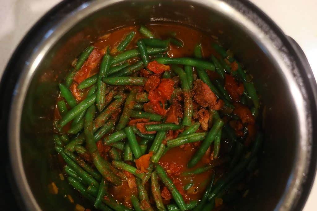 green beans and tomatoes cooking in pot