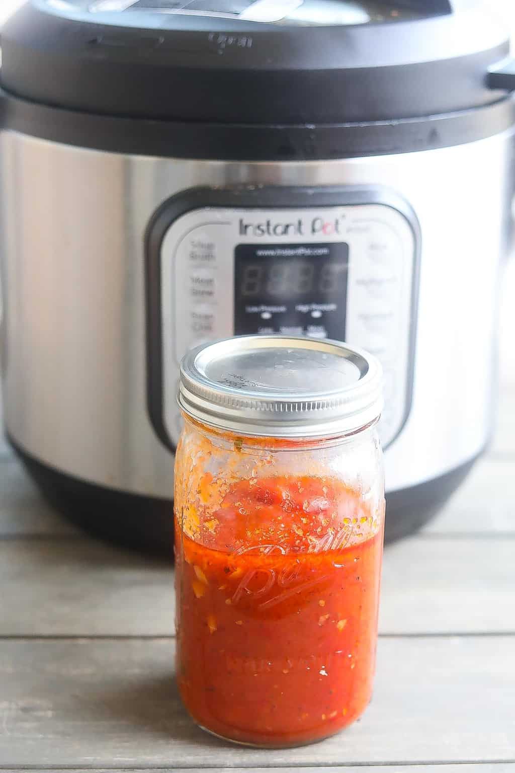 spaghetti sauce in a jar in front of instnat pot
