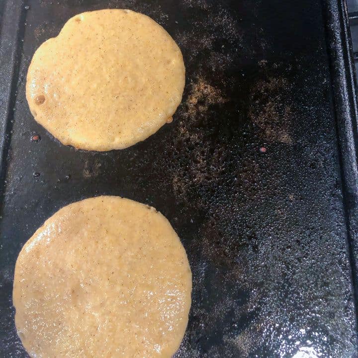pancakes cooking on a cast iron skillet