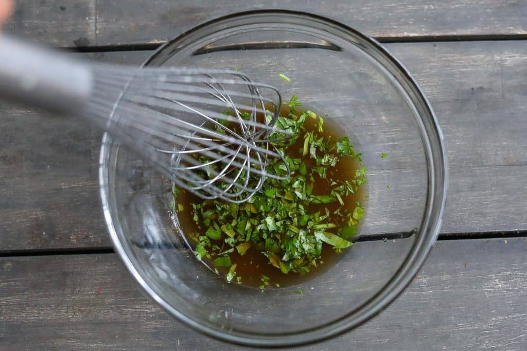 fish sauce with cilantro being whisked