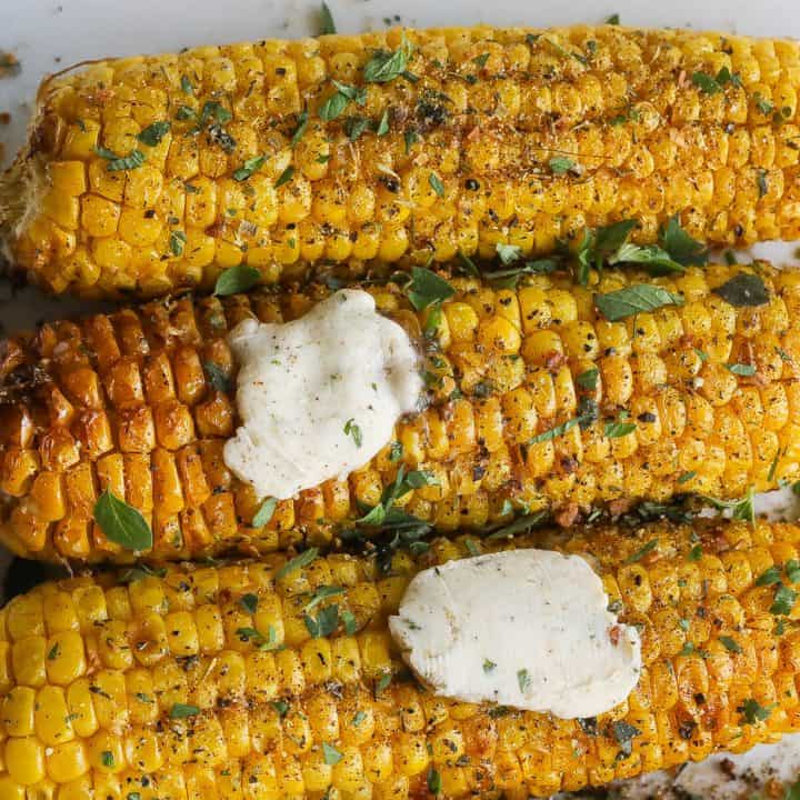 corn on the cob topped with fresh herbs and compound butter