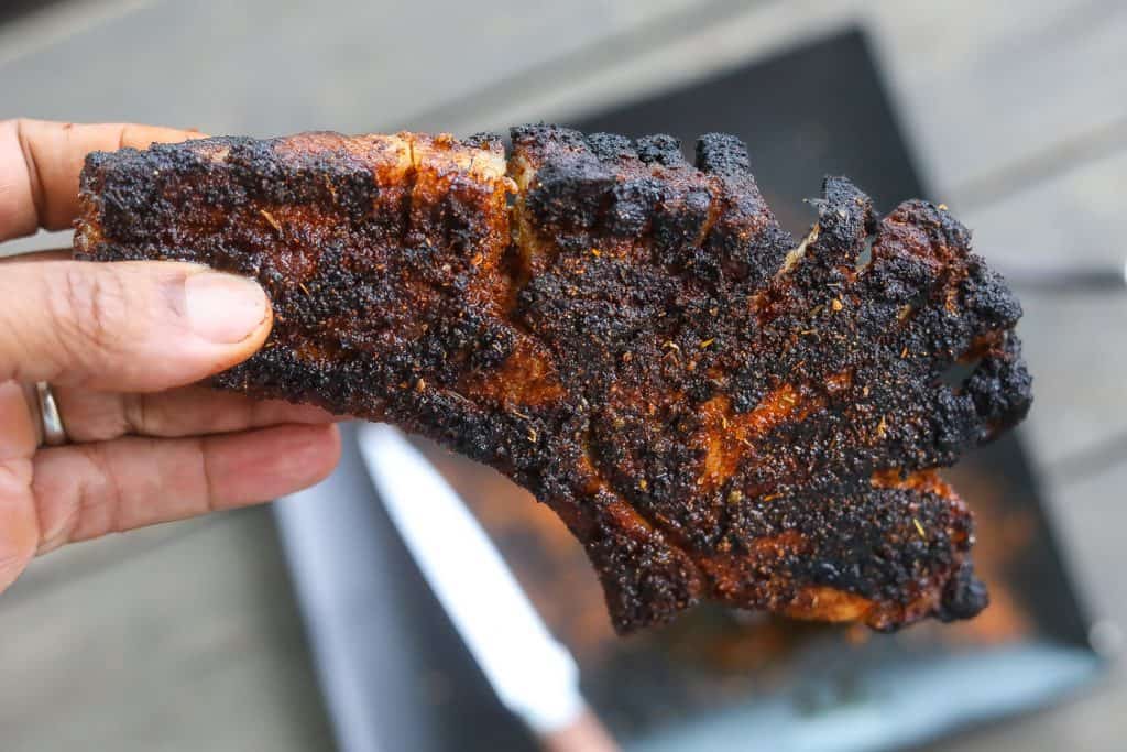 Blackened pork chop on black plate