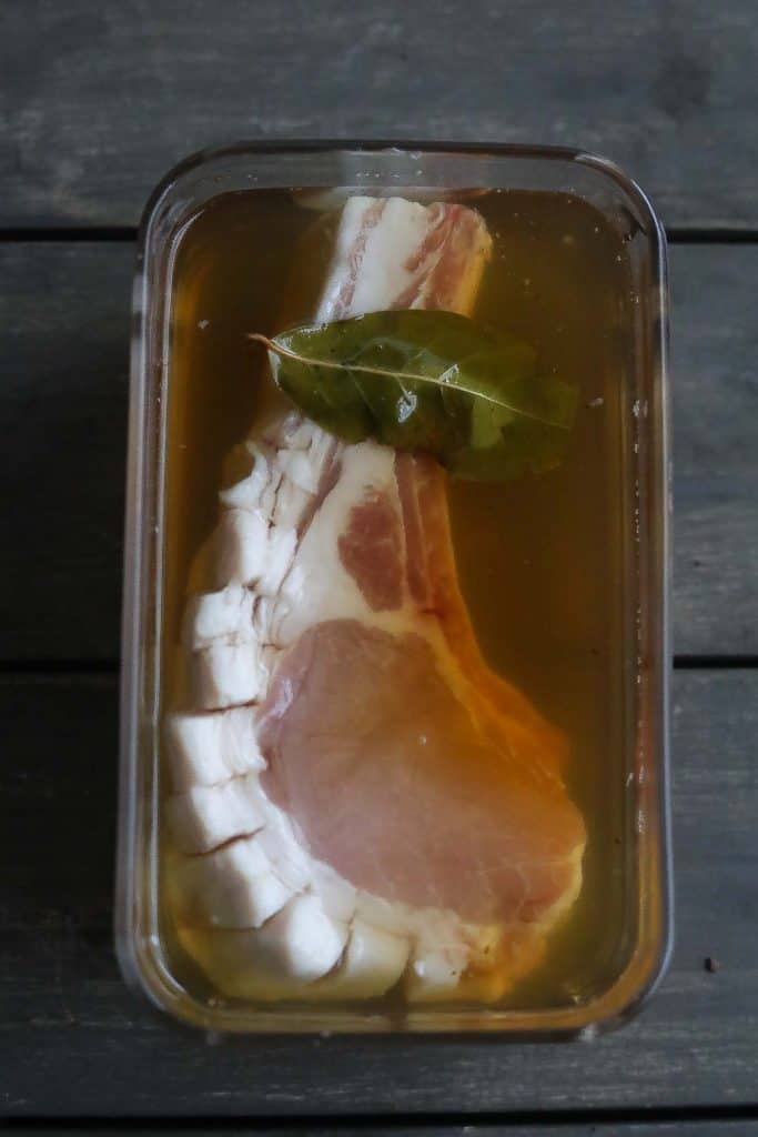 pork chop brining in glass container