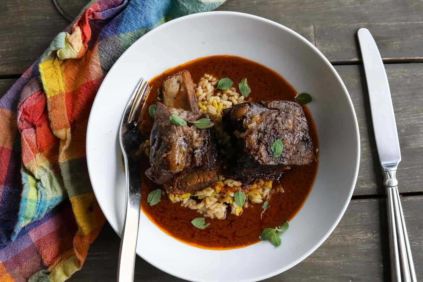 beef short ribs in white bowl with sauce