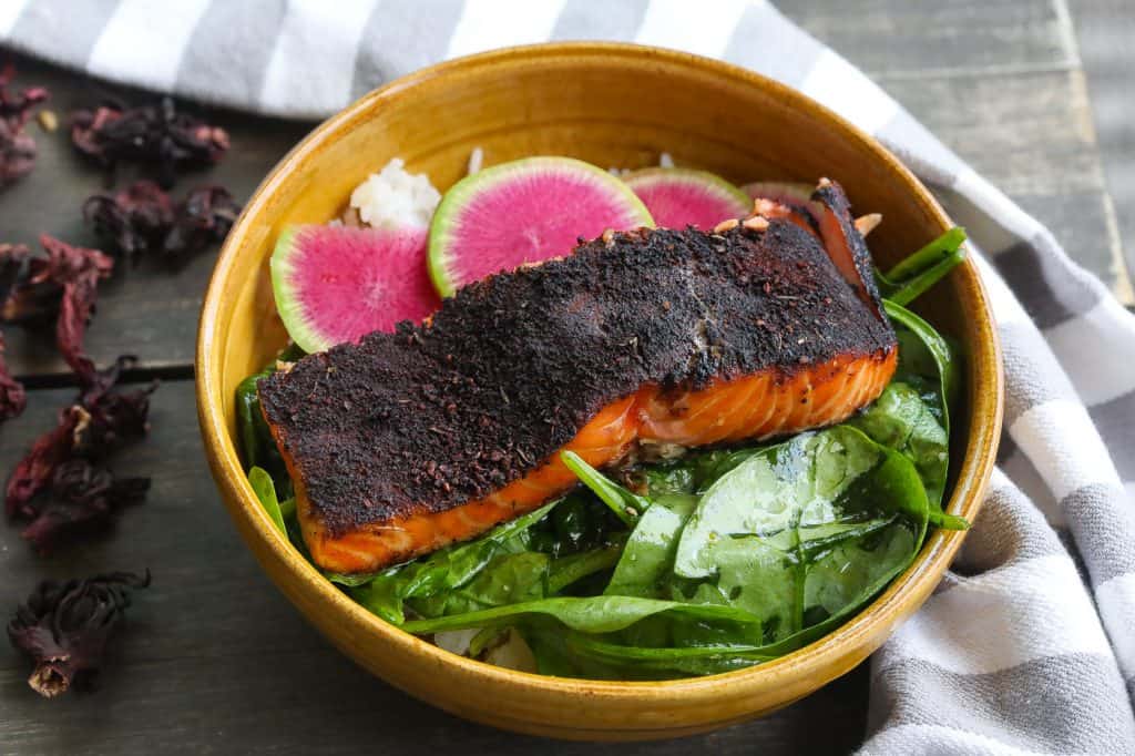cedar plank salmon on table with salad bowl