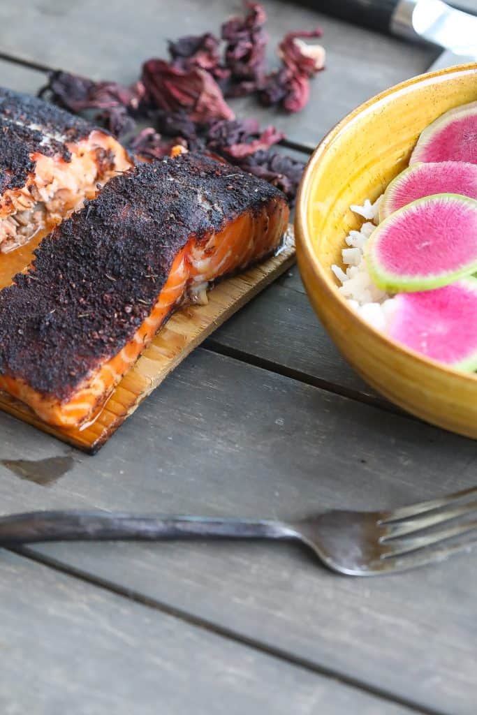 cedar plank salmon on table with salad bowl