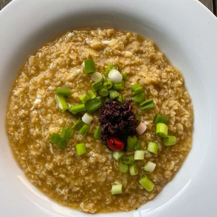 oatmeal in white bowl with green onions and chili paste