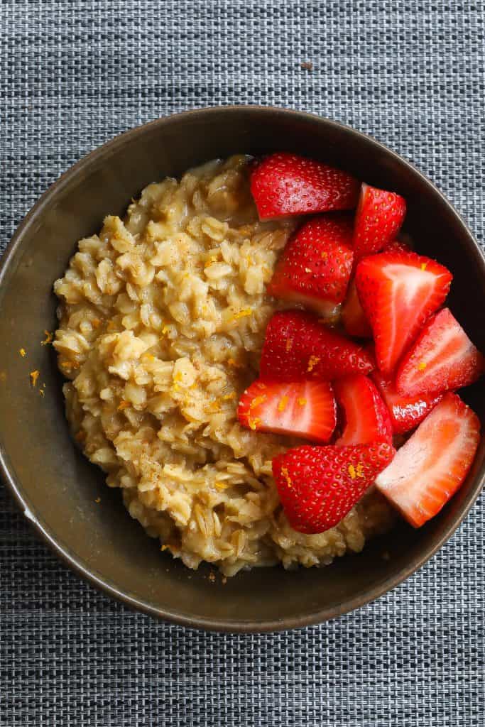 oatmeal topped with strawberries in brown bowl