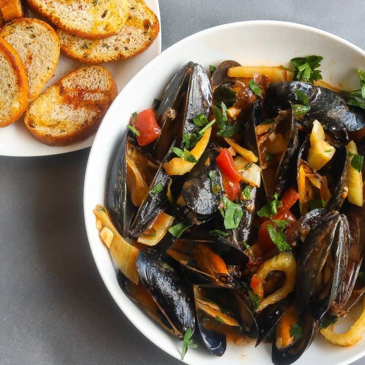 mussels in a bowl with a side of toast
