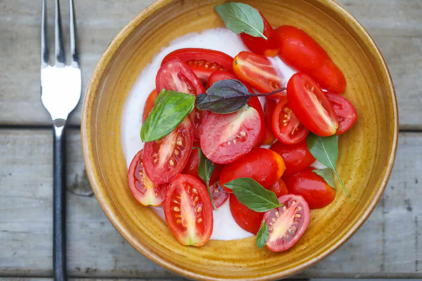 tomatoes and basil in a yellow bowl
