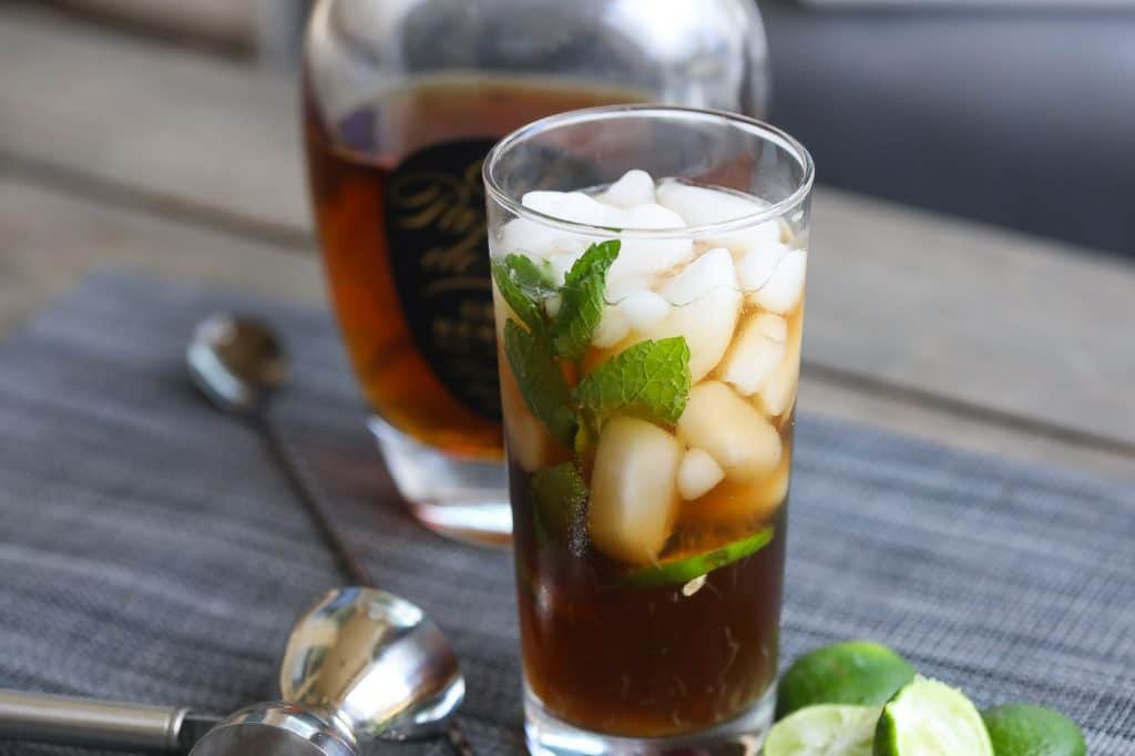 cuba libre cocktail in a tall glass with mint