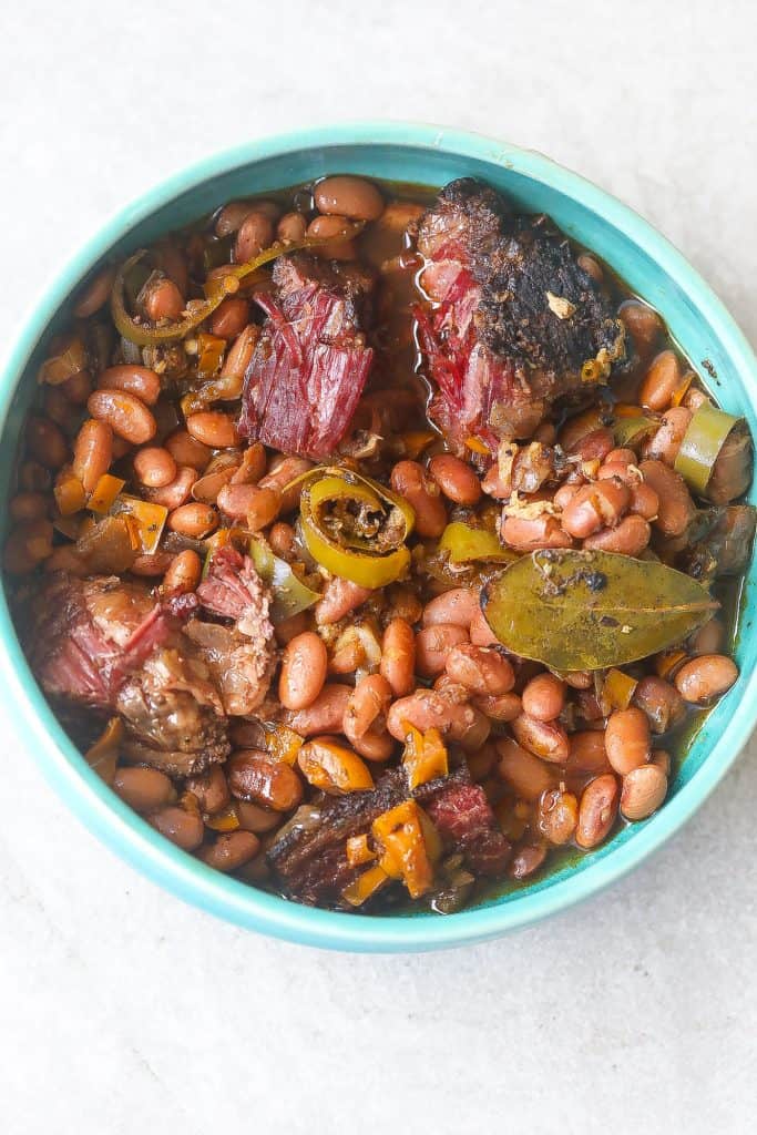 pinto beans with brisket in a blue bowl