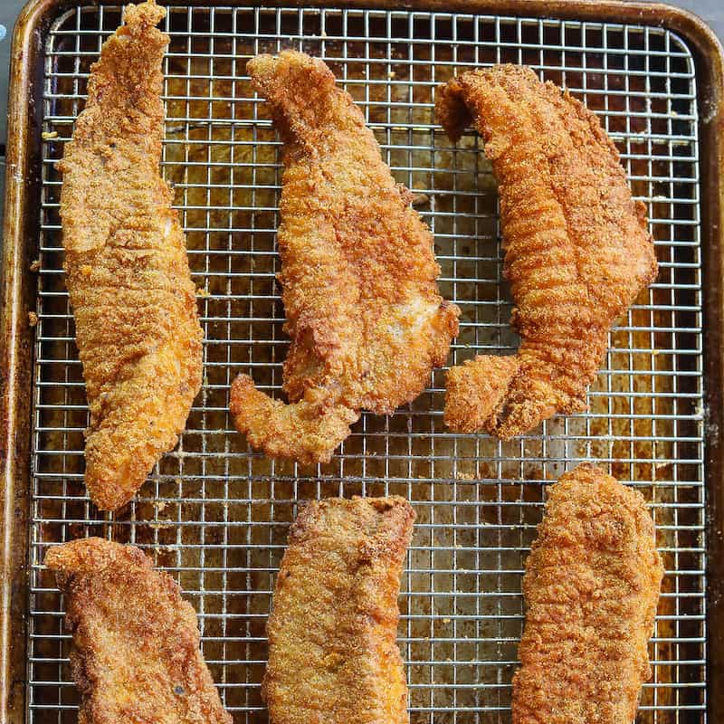 fried catfish fillets on a wire rack
