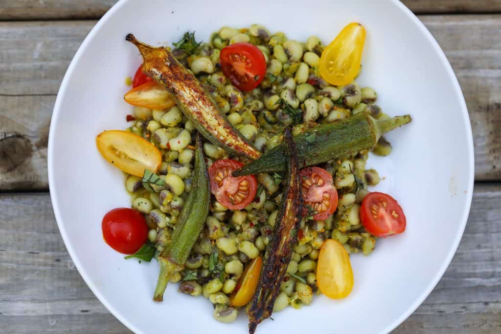 field peas, okra, and tomatoes in a white bowl