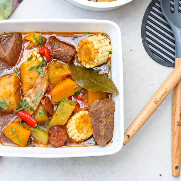 sancho stew in a square white bowl with corn, beef, and potatoes