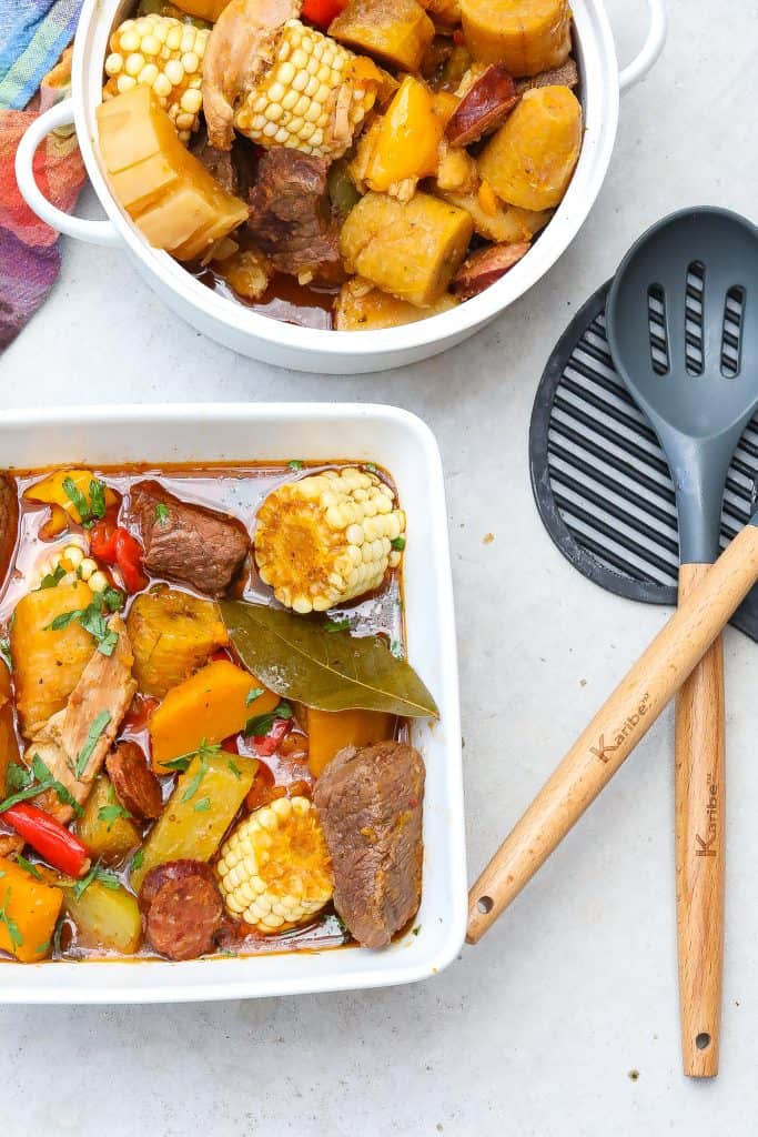 sancho stew in a square white bowl with corn, beef, and potatoes