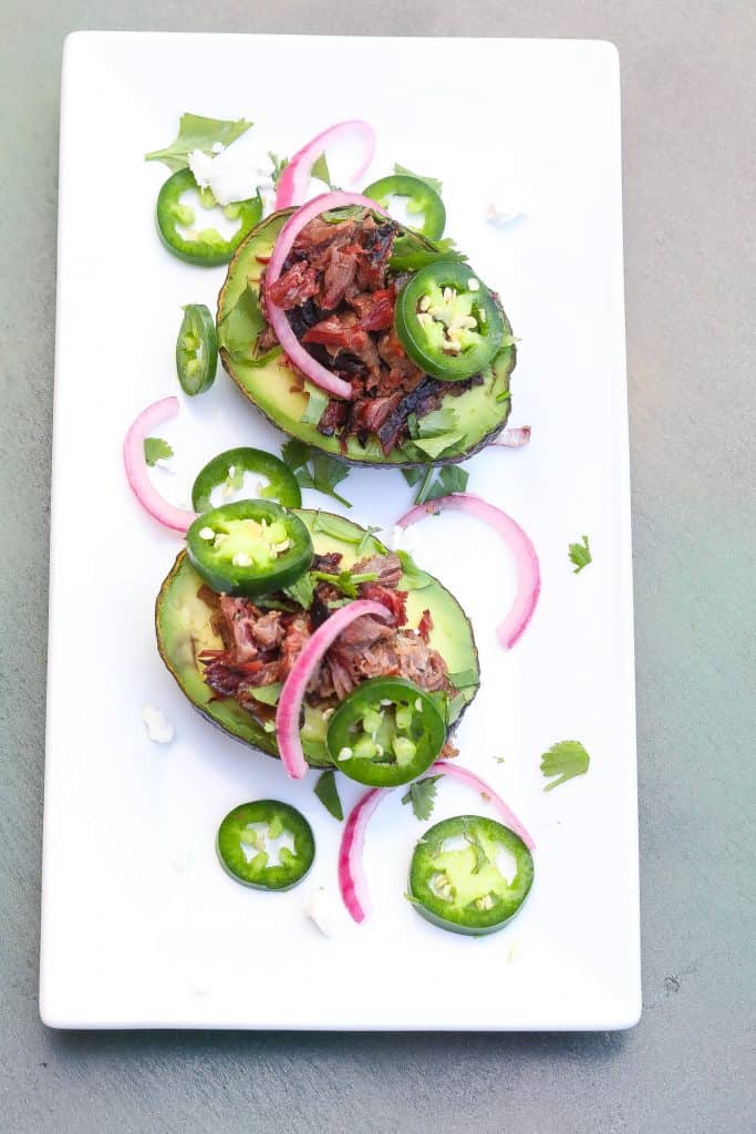 brisket stuffed avocados on white plate