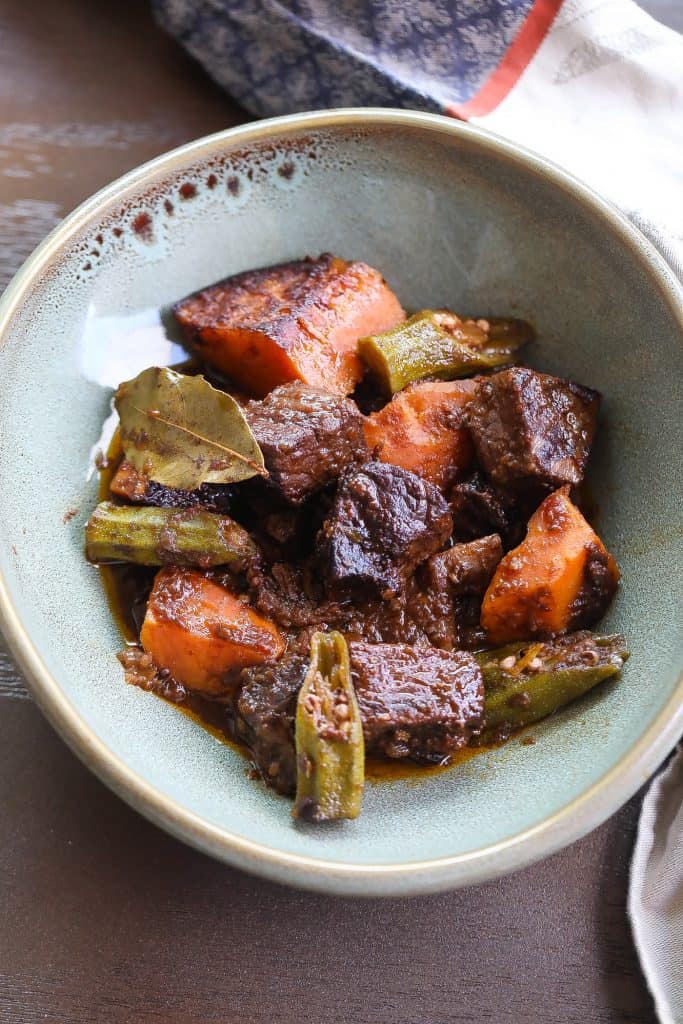 Beef stew with sweet potatoes in green bowl